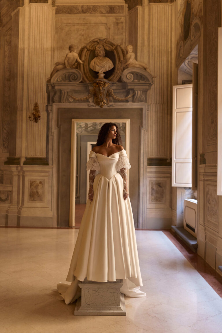 Darielle by Milla Nova at Wedding Belles of Four Oaks. Basque waist off the shoulder Wedding dress in plain fabric mikado