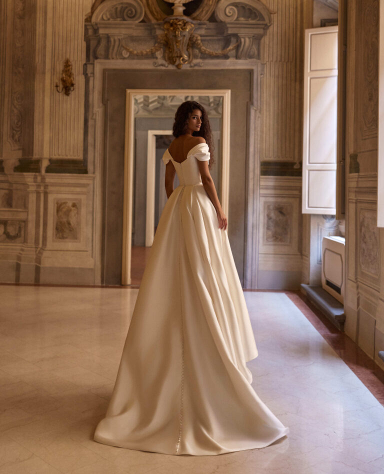 Darielle by Milla Nova at Wedding Belles of Four Oaks. Basque waist off the shoulder Wedding dress in plain fabric mikado