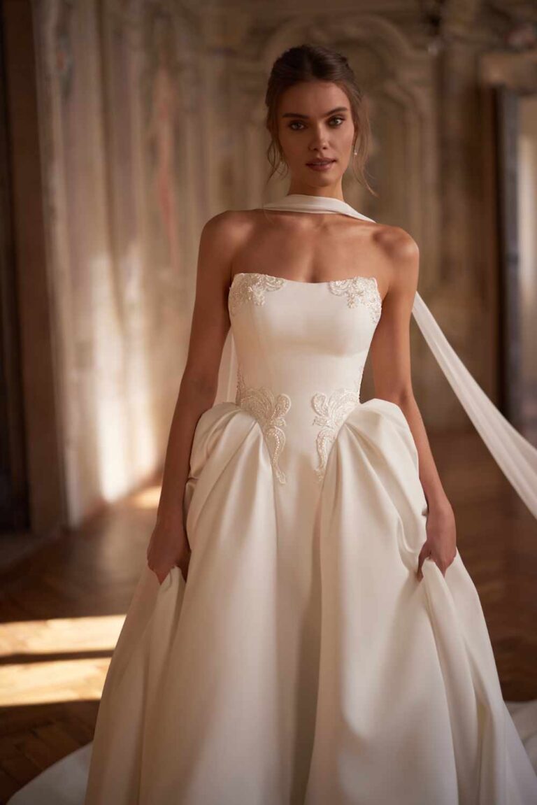 On trend basque waist ballgown wedding dress with lace detailing at Wedding Belles of Four Oaks