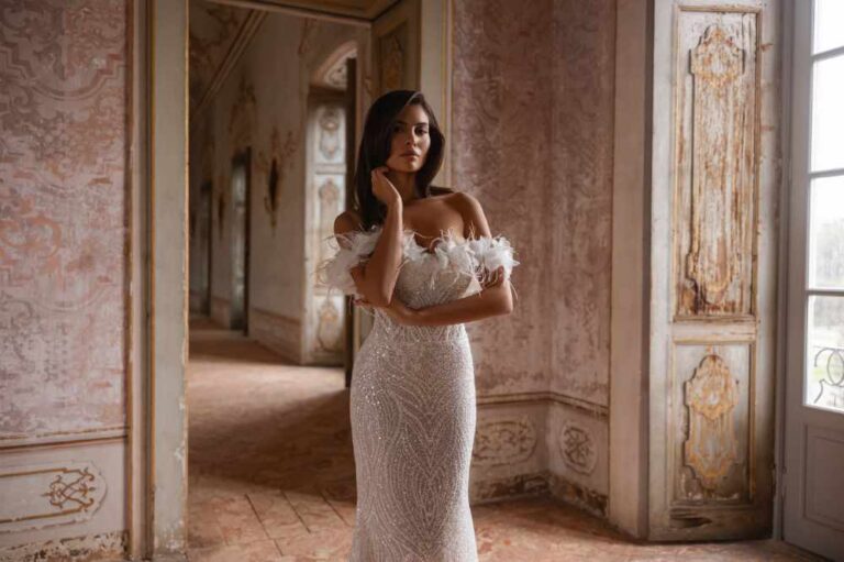 Raquel wedding dress is a glamorous beaded off the shoulder wedding Belles with detachable feather detail