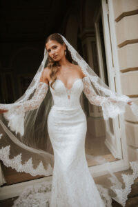Lyra by Lottie & Meg from Wedding Belles of Four Oaks Chantilly fitted lace Wedding dress with optional sleeves paired with cathedral lace veil